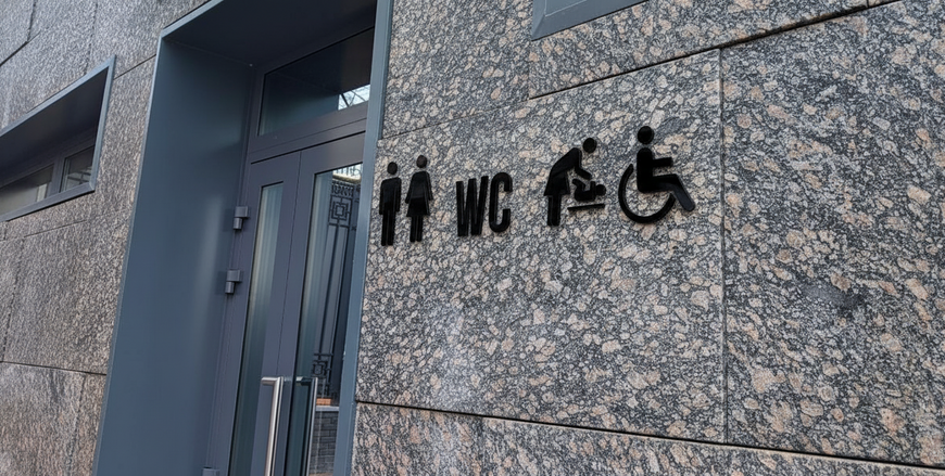 Minimalist sign, volumetric letters "WC" for toilet, gold-mirror